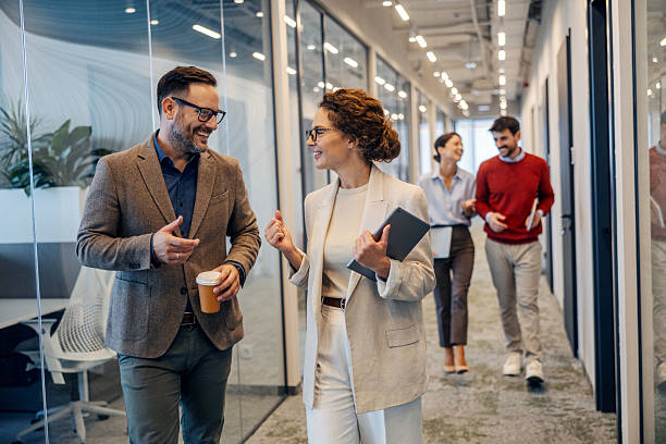 istock Business colleagues walking and talking in office hallway 2243620209