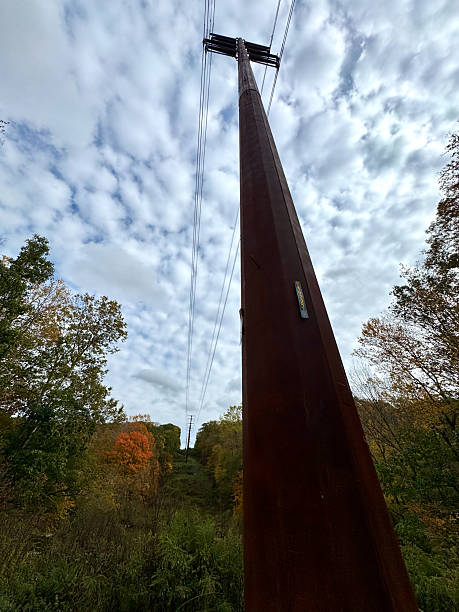 istock Vertical EX low wide angle tall metal power line pole under cloudy sky 2243621110