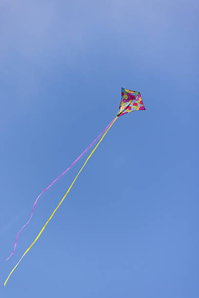 istock Low angle view of colorful Kite flying in blue sky 2243624640