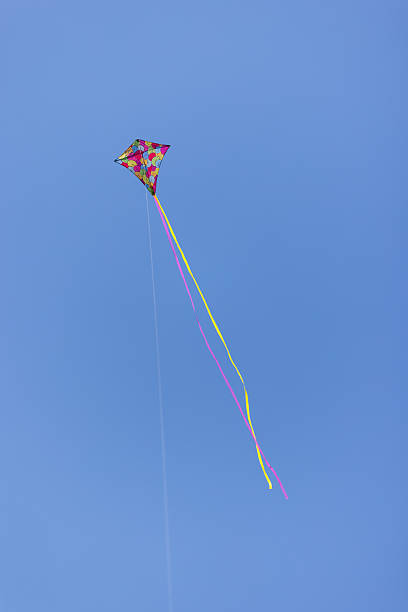 istock Low angle view of colorful Kite flying in blue sky 2243624668