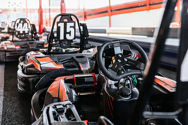 Go-karts lined up on an outdoor racing circuit, empty and ready for drivers to experience high-speed fun and competitive karting action