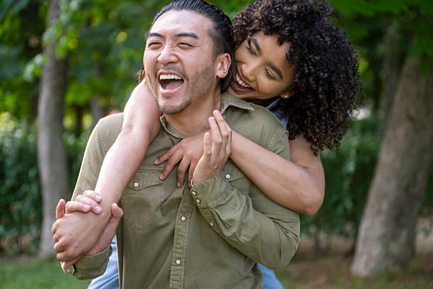 istock Interracial couple laughing and embracing in park 2243630822