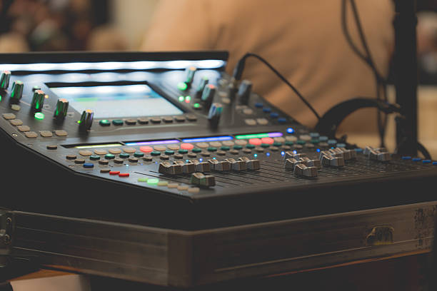 istock Sound engineer adjusting audio mixing console with colorful lights and controls in studio or live concert setup 2243634001