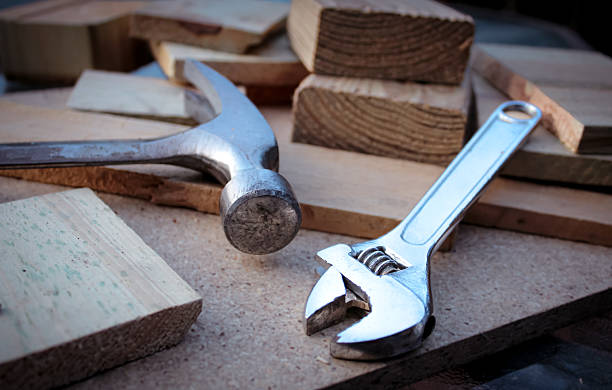 istock A hammer and an adjustable wrench rest on a rustic wood background. 2243634989