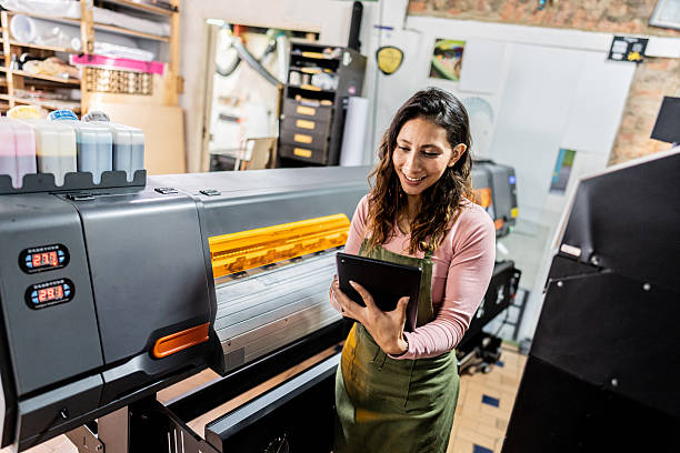 istock Digital printing operator checking tablet in commercial print facility 2243642268
