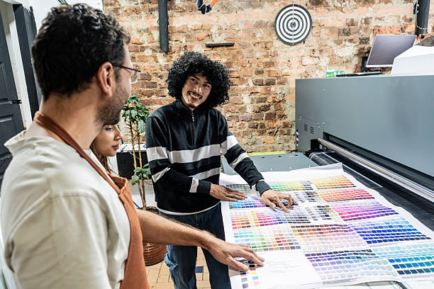 istock Digital printing office colleagues reviewing printed materials and color samples 2243642435