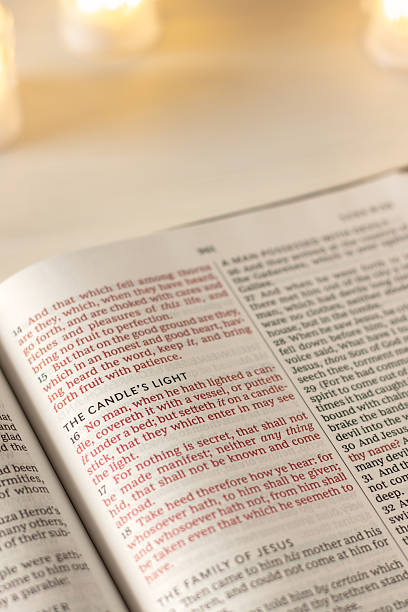 istock Candle's light inspirational text in open holy bible book 2243648431