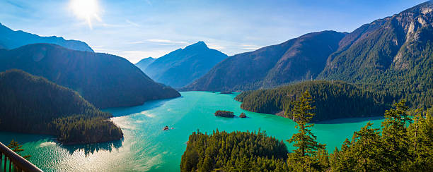 A wide panoramic view captures the vast, distinctive turquoise waters of Diablo Lake from a high overlook, surrounded by the dramatic mountains in North Cascades National Park.