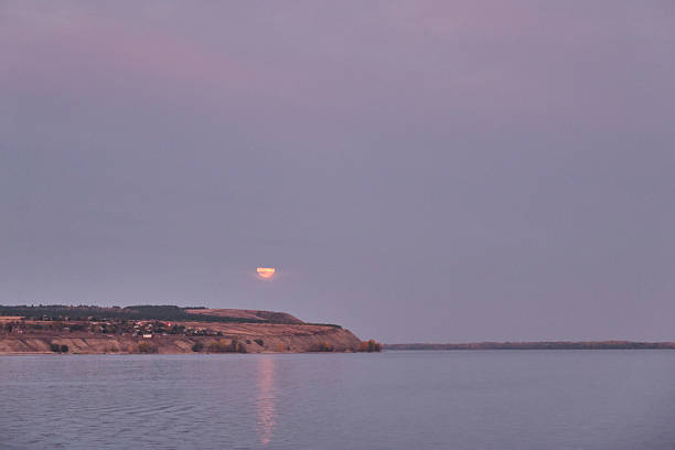 Crescent moon rising over the sea and the lighthouse with copy space.