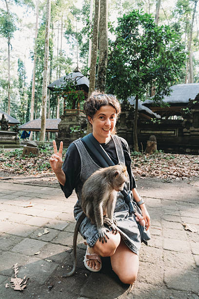 istock Woman smiling with monkey on her lap in Bali 2243659414