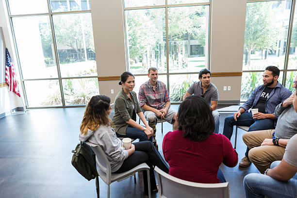 istock Group session with diverse adults sharing during a therapeutic meeting 2243660503