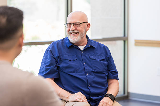 istock Man smiles warmly, showing understanding and support to another person in conversation. 2243660539