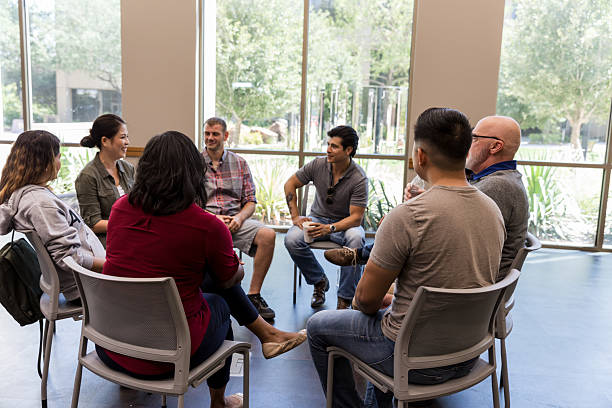 istock Diverse group of adults sitting in a circle, engaging in supportive conversation indoors. 2243660555