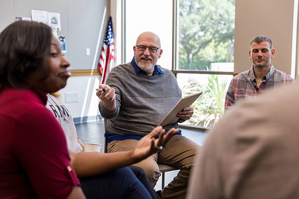 istock Diverse group participates in therapy session with male facilitator. 2243660558