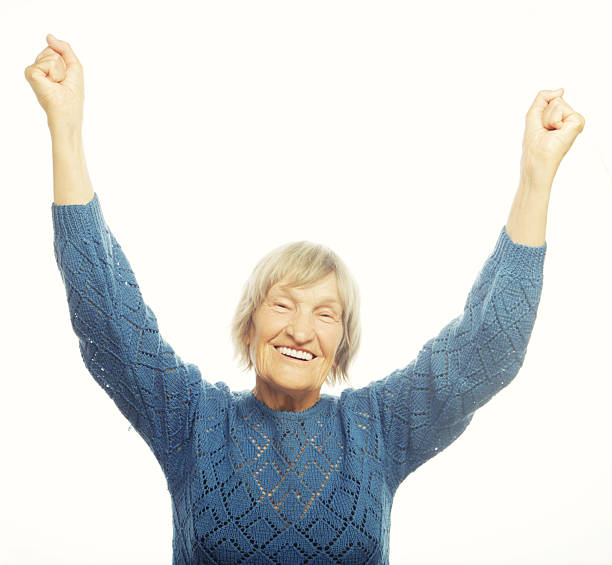 istock cheerful senior woman gesturing victory 2243660802