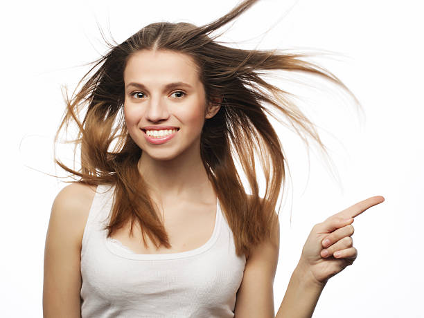 istock happy woman poiting finger up at copyspace isolated on a white 2243661172