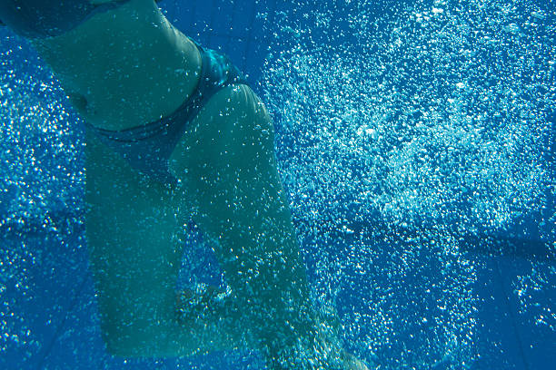 Woman with swimsuit swimming on a blue water pool