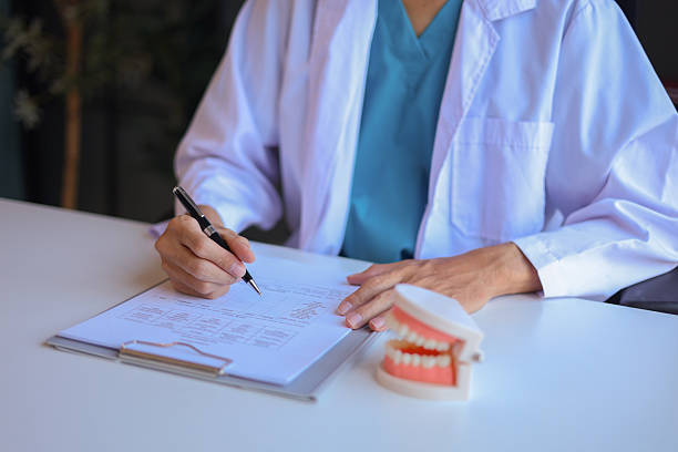 istock Dentist working in office writing diagnose oral health issues. 2243662380