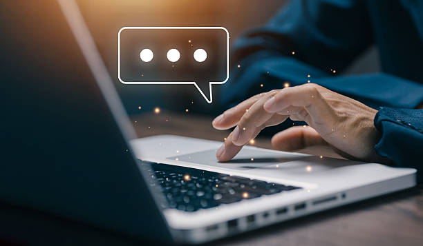 istock Business hand typing on laptop with floating chat bubble icon. Concept of digital communication, online conversation, social media messaging, and workplace collaboration. 2243663895