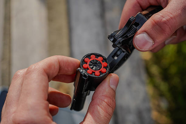 istock Close-up of hands loading a toy cap gun with red ring caps. 2243671748