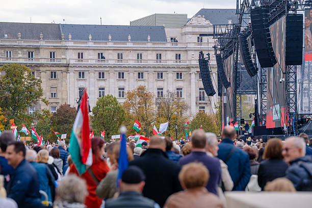 Budapest, Hungary - October 23, 2025: Crowd gathered in Budapest for the October 23 national commemoration, waving Hungarian flags as Prime Minister Viktor Orban delivers his speech from.