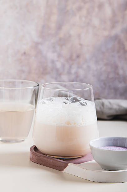 istock Cloudy pink matcha with coconut water in a glass on the table vertical view 2243673089