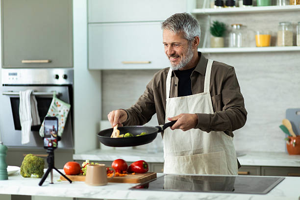 istock Mature man cooking fresh vegetables for online culinary blog 2243673399