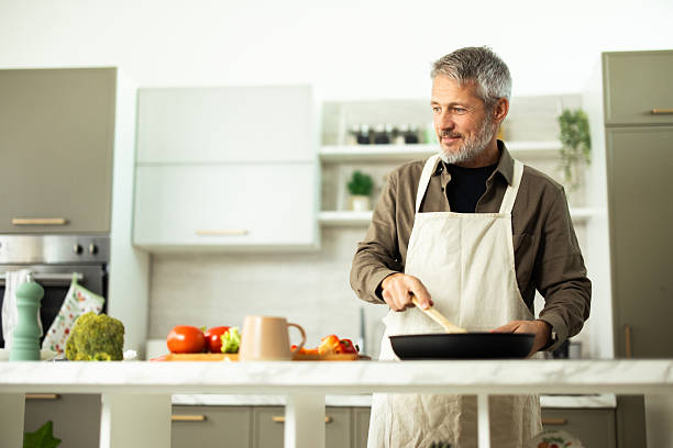 istock Senior man cooking healthy meal in modern kitchen 2243673479