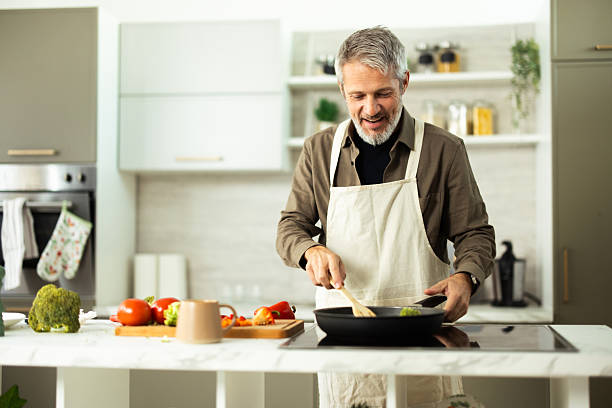 istock Senior man cooking healthy vegetables in modern kitchen 2243673481
