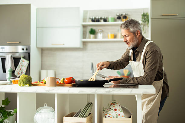 istock Mature man cooking healthy meal with vegetables in modern kitchen 2243673491