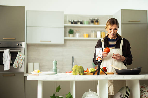 istock Woman vlogging cooking recipe in modern kitchen 2243673514