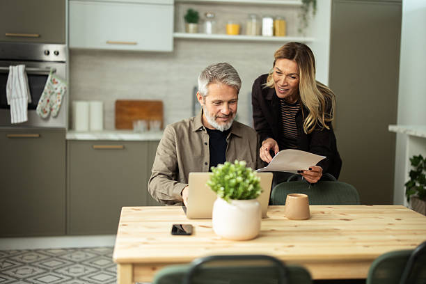 istock Senior couple planning finances using laptop at home 2243673742