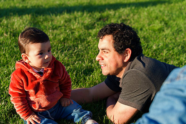 Father and baby son spending time together in grass, symbolizing family love and connection