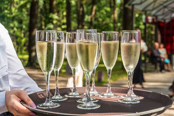 istock Champagne Glasses on Tray in Park Setting 2243678132