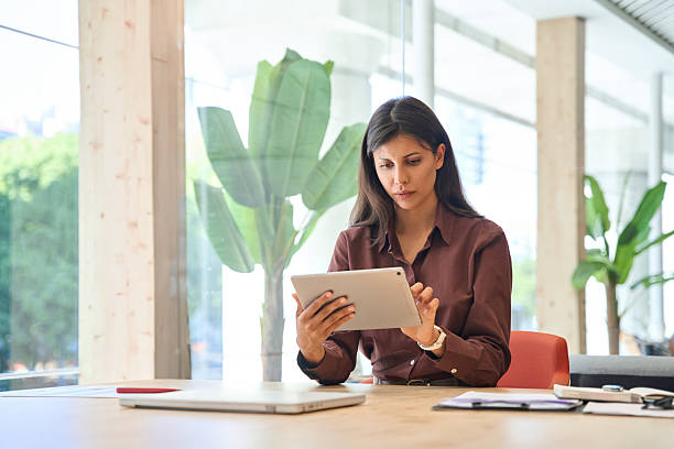istock Focused latin hispanic young woman using pad computer for business analysing. Busy executive CEO businesswoman professional holding digital tablet pc device working in office workplace. Copy space 2243679734