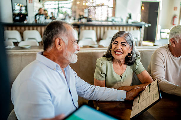istock Senior couple looking menu during dinner with friends at restaurant 2243681242