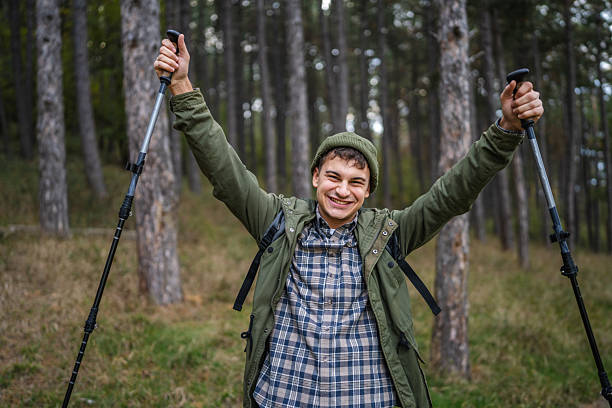 istock Happy young man celebrating success during hiking in forest 2243682579