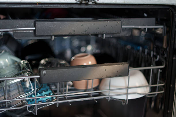 istock close-up view of a dishwasher rack loaded with clean glassware and ceramic dishes, featuring water droplets indicating recent washing cycle in a modern kitchen setting, indoors, technology, housing 2243687288