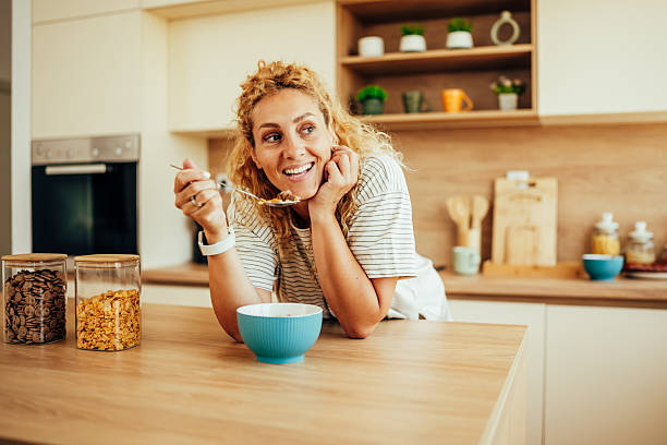 istock Happy woman eating healthy breakfast cereal in kitchen 2243687481
