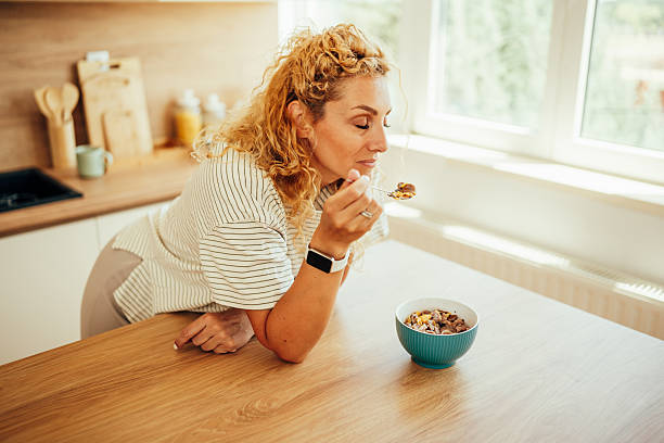istock Woman eating healthy breakfast cereal in her kitchen 2243687501