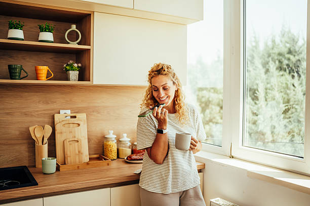 istock Woman talking on phone, drinking coffee in kitchen 2243687511