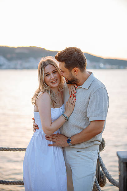 istock Young couple laughing and embracing on the beach 2243688345