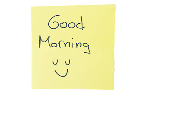 Yellow sticky note with handwritten morning greeting and a hand-drawn smiling face