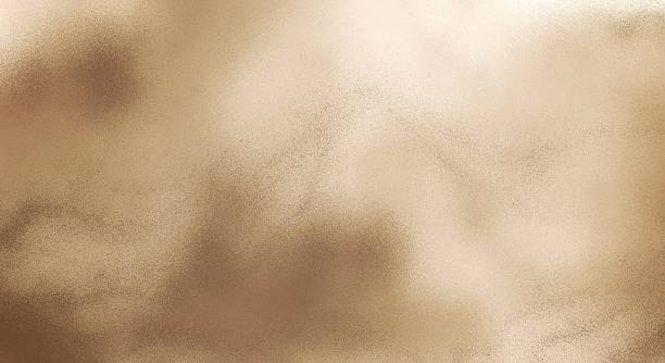 The golden-beige brown texture background gives the impression of fine, scattered sand dust, softly blurred, like the sand that has been blown by the wind to create a diffused pattern.