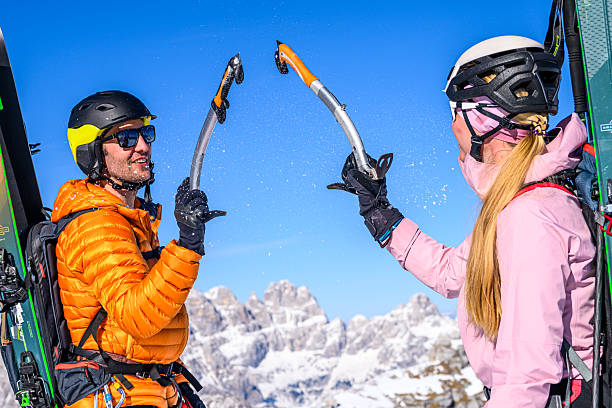 istock Two Skiers High-five on Snowy Mountain Peak 2243696893