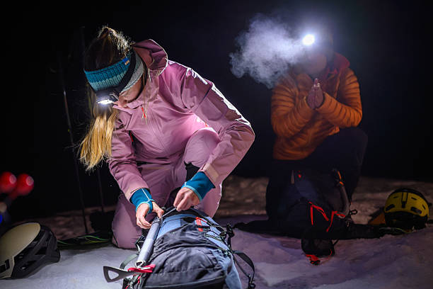 istock Climbers in Winter Gear Prepare Equipment in Snowy Nighttime Setting 2243696954