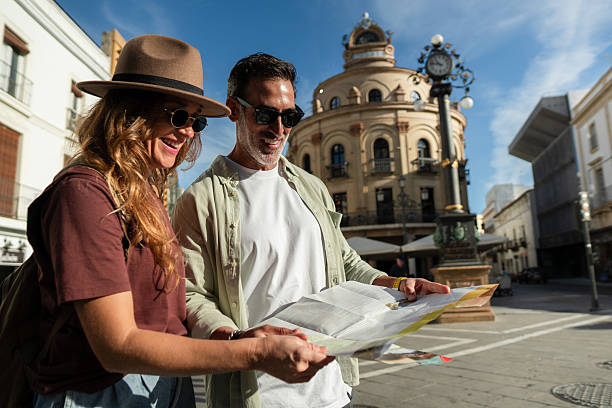 Couple navigating city streets with a map, enjoying their travel adventure