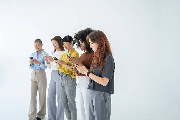 istock Five young businesswomen using their smartphones on white background 2243697482