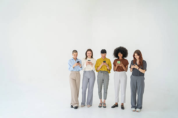 istock Five young businesswomen using their smartphones in a modern office 2243697485