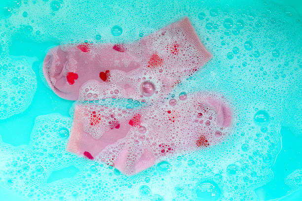 istock Pink socks with red heart patterns soaking in soapy water 2243699387